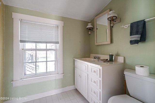 bathroom with tile floors, lofted ceiling, toilet, and vanity