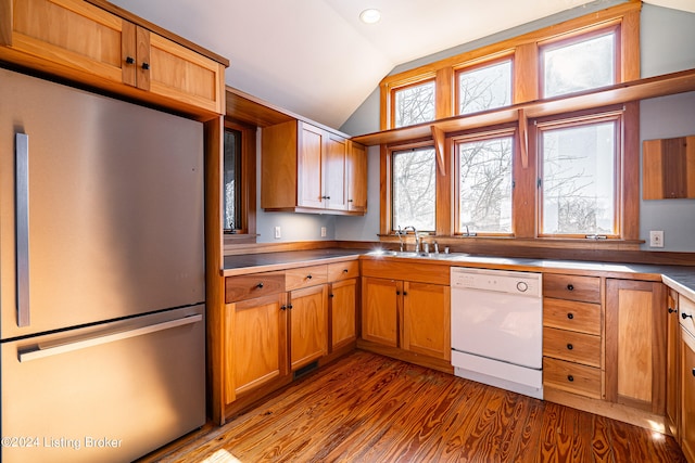 kitchen with stainless steel refrigerator, dark wood-type flooring, lofted ceiling, sink, and white dishwasher