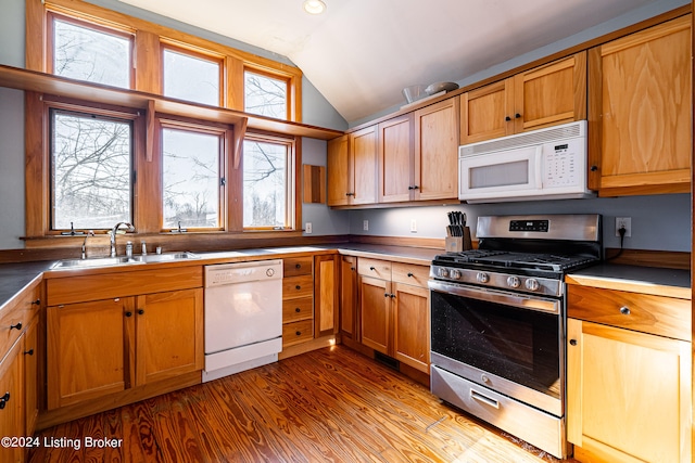 kitchen with lofted ceiling, white appliances, sink, and light wood-type flooring