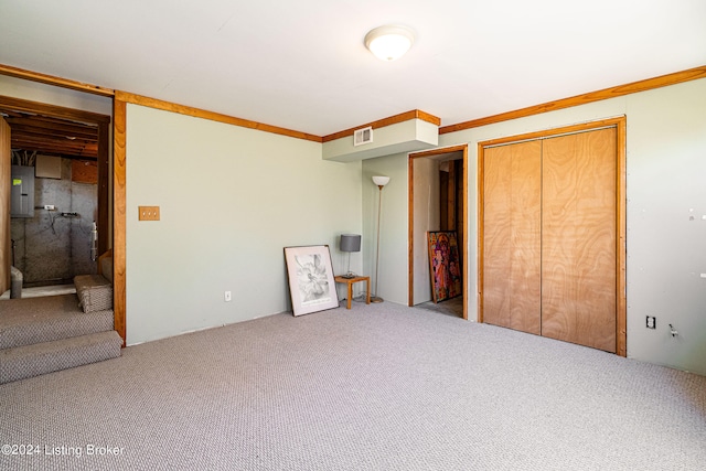 unfurnished bedroom featuring light carpet, ornamental molding, and a closet