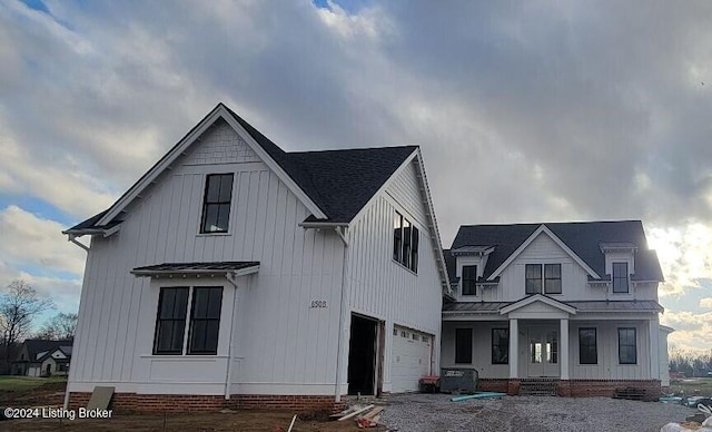 modern inspired farmhouse featuring a garage, crawl space, covered porch, and metal roof