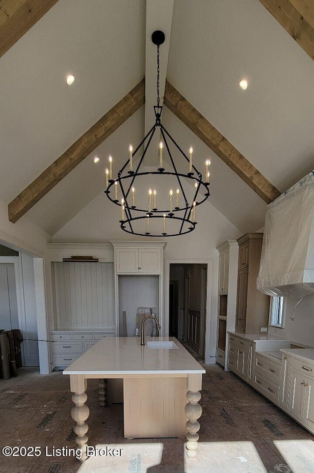 kitchen with high vaulted ceiling, a sink, light countertops, beam ceiling, and a large island with sink