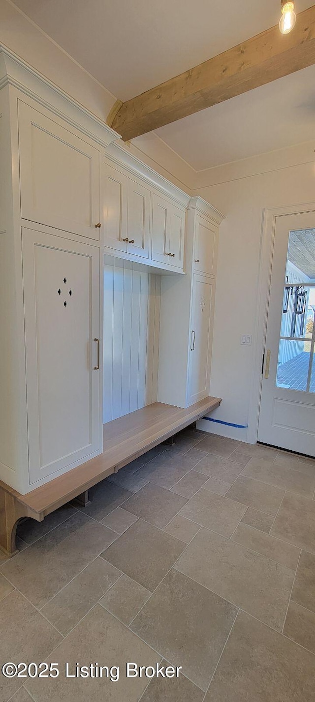 mudroom featuring stone finish flooring and beamed ceiling