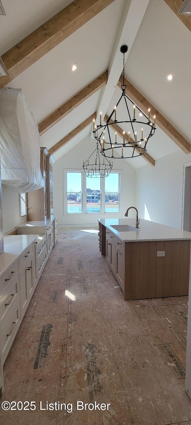 kitchen with hanging light fixtures, light countertops, a sink, and a large island with sink