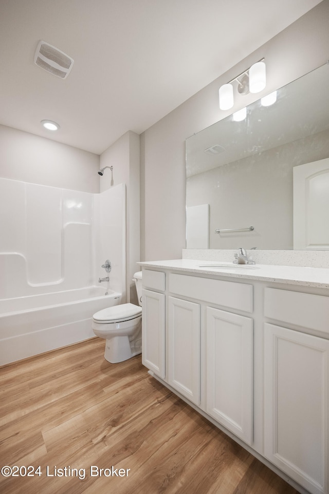 full bathroom featuring wood-type flooring, vanity, toilet, and bathtub / shower combination