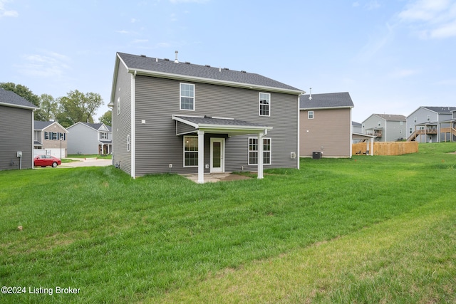 back of property with central AC unit, a lawn, and a patio area