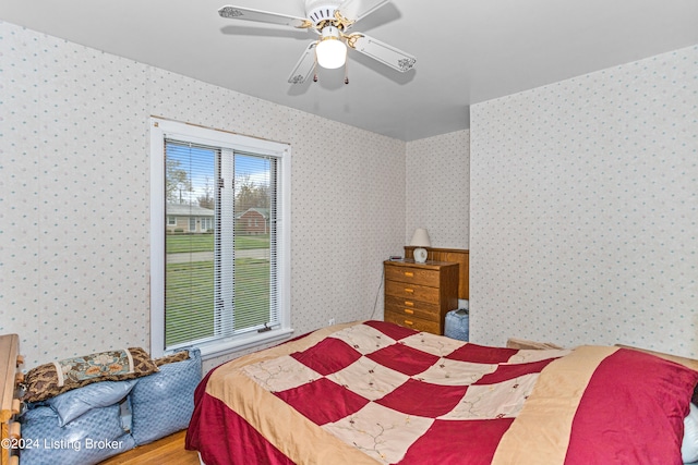 bedroom featuring ceiling fan, light hardwood / wood-style flooring, and multiple windows