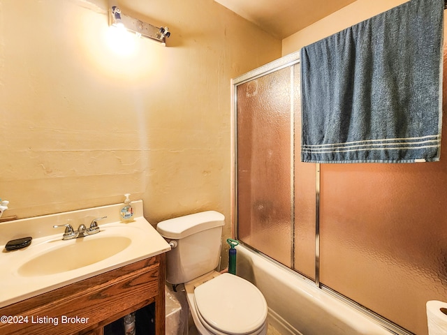 full bathroom with toilet, vanity, and bath / shower combo with glass door