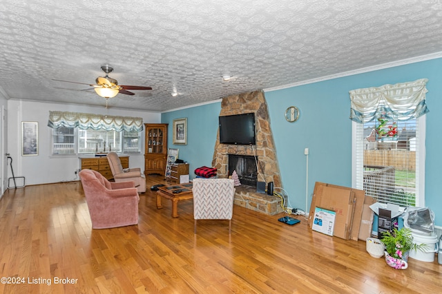 living room with ornamental molding, a healthy amount of sunlight, and light hardwood / wood-style flooring