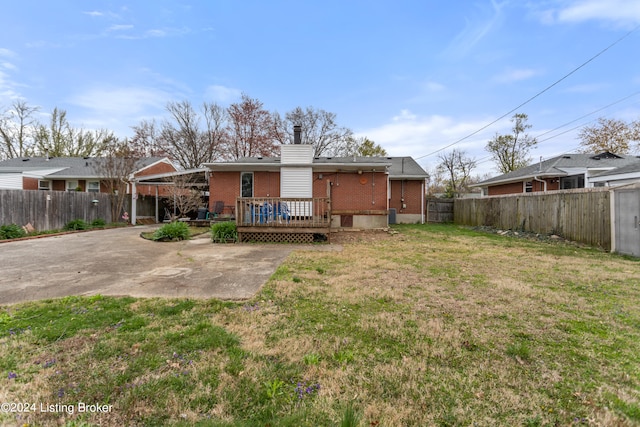 rear view of property featuring a wooden deck and a yard