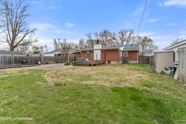 back of house featuring a wooden deck and a yard