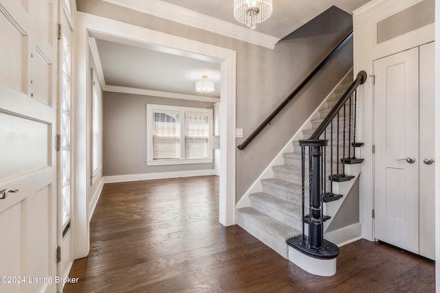 foyer featuring a notable chandelier, ornamental molding, and dark hardwood / wood-style floors