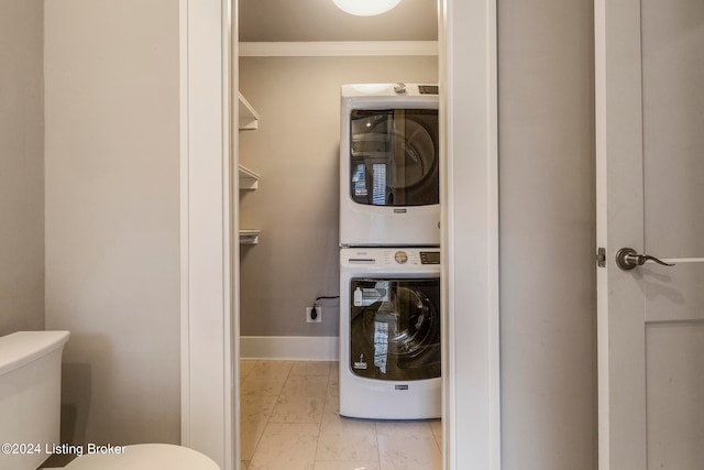 laundry room featuring light tile floors, crown molding, and stacked washer / drying machine