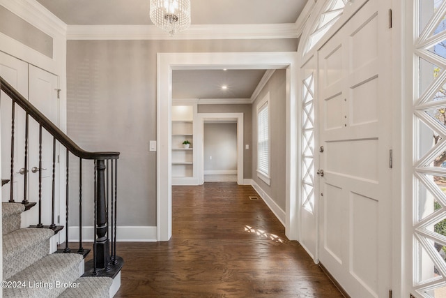 entrance foyer with an inviting chandelier, ornamental molding, dark wood-type flooring, and a wealth of natural light