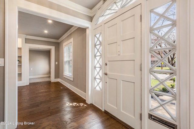 foyer entrance with a healthy amount of sunlight, crown molding, and dark hardwood / wood-style flooring