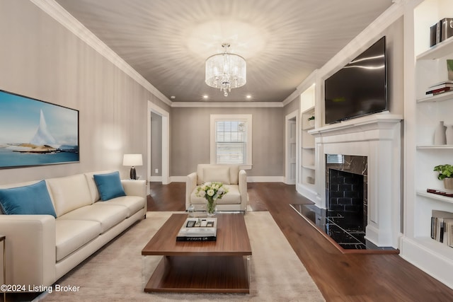 living room featuring a notable chandelier, a premium fireplace, built in shelves, crown molding, and dark hardwood / wood-style flooring