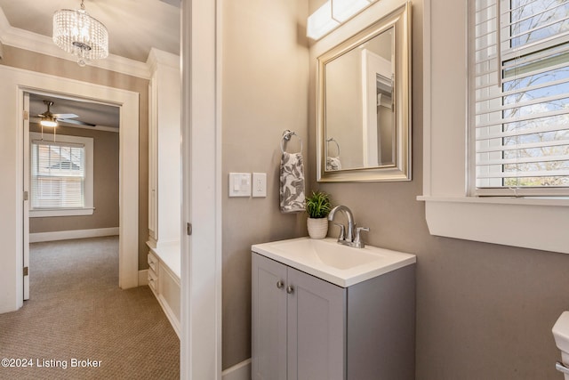 bathroom featuring ornamental molding, vanity, and ceiling fan with notable chandelier