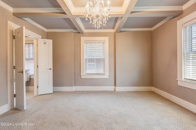 unfurnished room featuring coffered ceiling, a notable chandelier, a healthy amount of sunlight, and light carpet