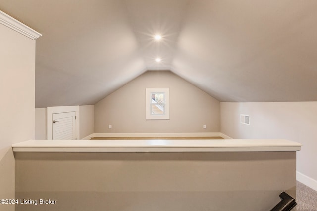 bonus room with lofted ceiling and carpet