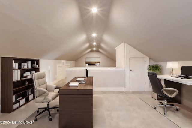 carpeted home office with vaulted ceiling