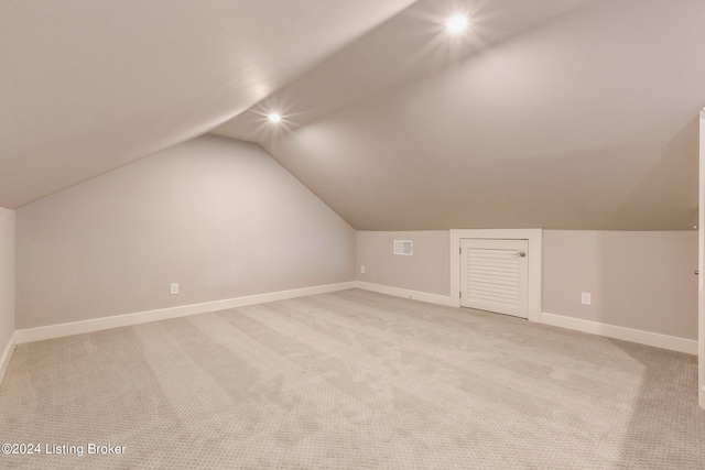 bonus room with light carpet and vaulted ceiling