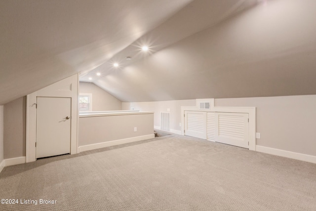 additional living space with lofted ceiling and light colored carpet