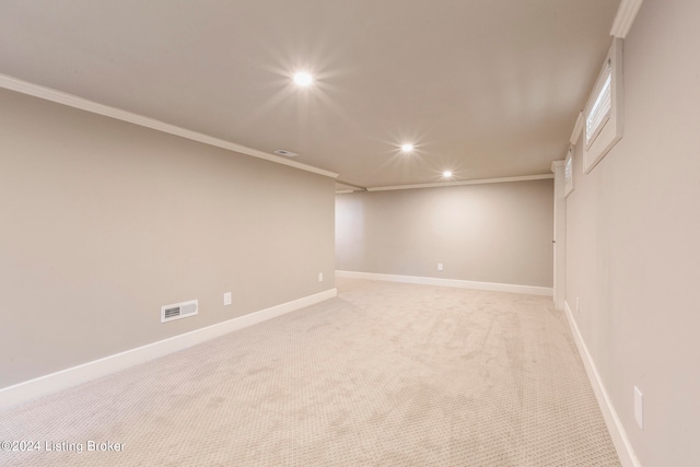 empty room with crown molding and light colored carpet