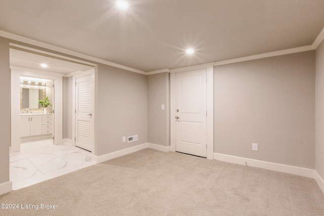 carpeted empty room with crown molding and sink