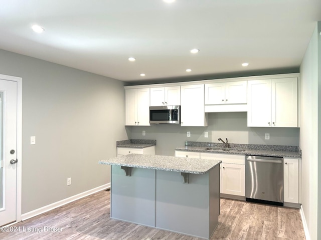 kitchen featuring sink, a center island, white cabinets, and appliances with stainless steel finishes