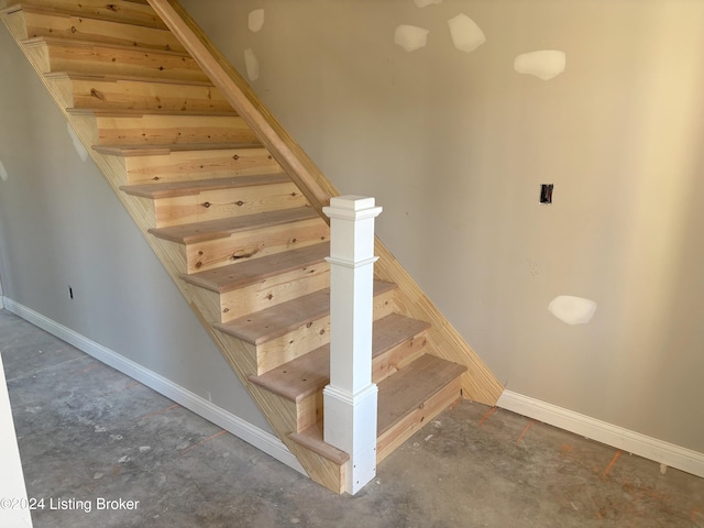 stairs with concrete flooring