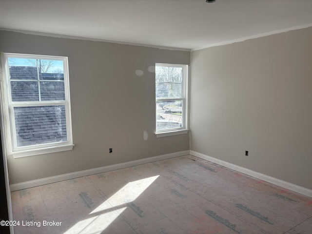 spare room with a healthy amount of sunlight and crown molding