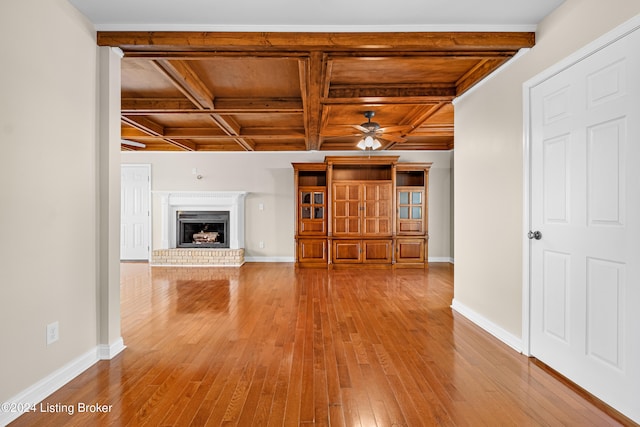 unfurnished living room featuring coffered ceiling, beam ceiling, and hardwood / wood-style floors