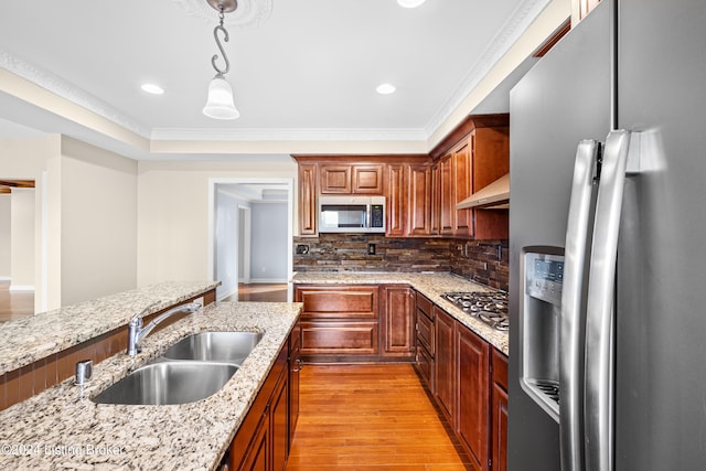 kitchen with appliances with stainless steel finishes, sink, light hardwood / wood-style floors, backsplash, and ornamental molding