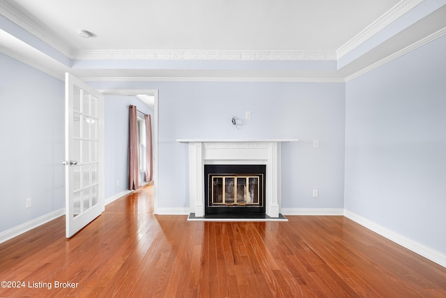 unfurnished living room with hardwood / wood-style floors and crown molding