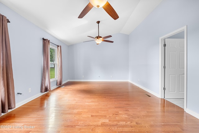 empty room with ceiling fan, vaulted ceiling, and light wood-type flooring