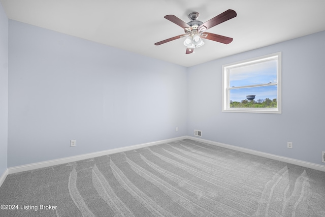 unfurnished room with ceiling fan and carpet