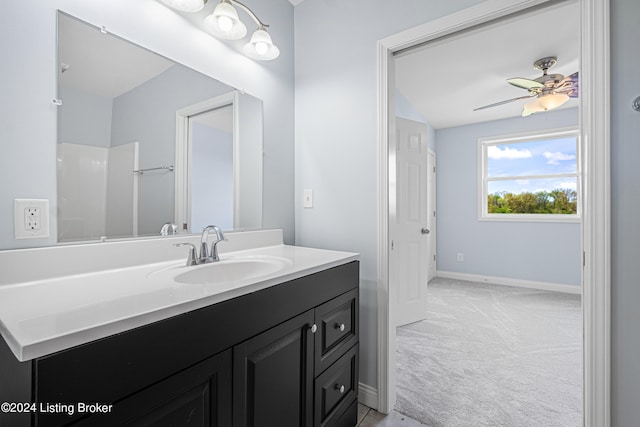 bathroom featuring ceiling fan and large vanity