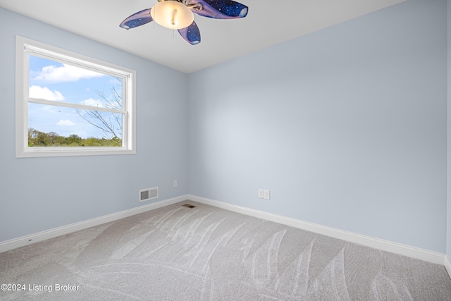 unfurnished room with a wealth of natural light, carpet, and ceiling fan