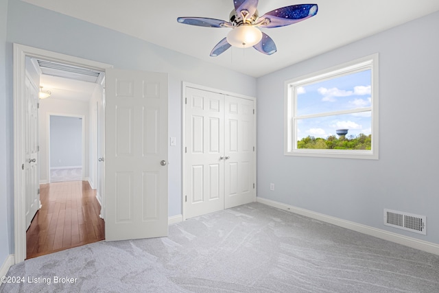 unfurnished bedroom featuring a closet, ceiling fan, and carpet flooring