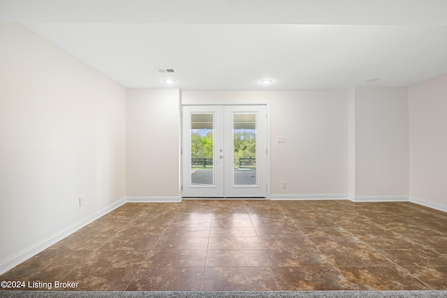 unfurnished room featuring french doors and dark tile flooring