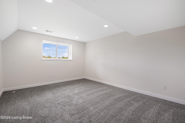 spare room featuring vaulted ceiling and carpet