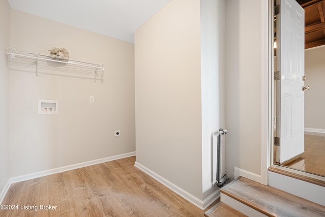 clothes washing area featuring radiator, light hardwood / wood-style floors, washer hookup, and electric dryer hookup