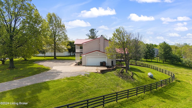 view of yard with a rural view and a garage