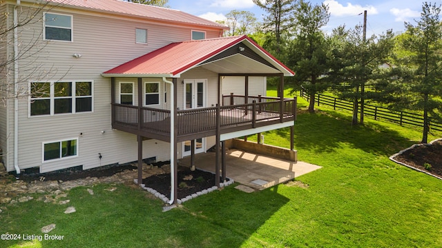 rear view of property featuring a patio, a lawn, and a deck