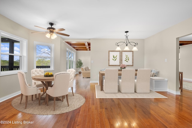 dining room featuring beamed ceiling, light hardwood / wood-style flooring, and ceiling fan