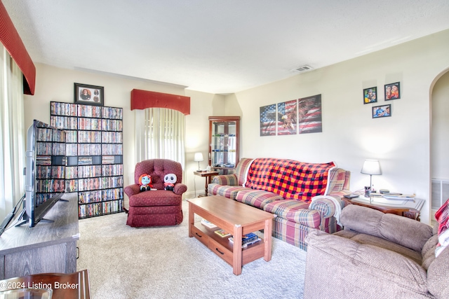 living room with visible vents, carpet, and arched walkways