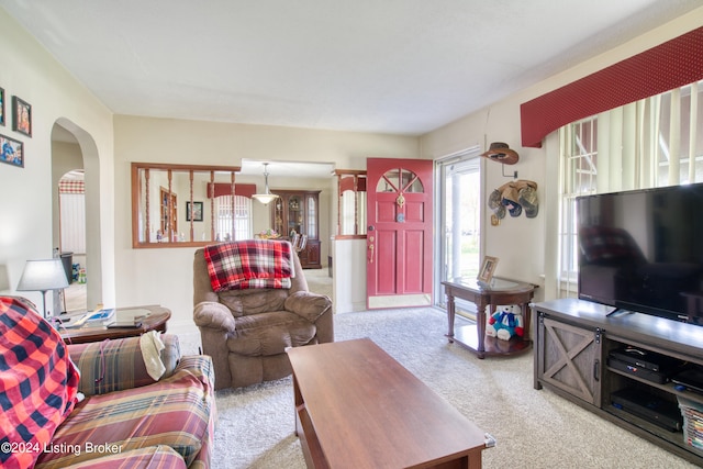 living room featuring carpet and arched walkways