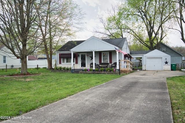 bungalow-style home with an outbuilding, covered porch, fence, a detached garage, and a front yard