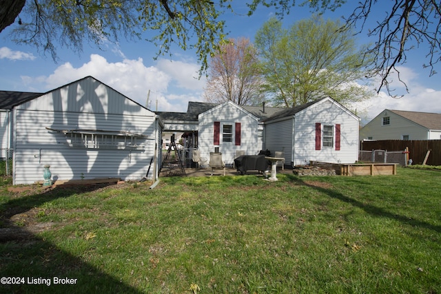 back of house featuring fence and a lawn