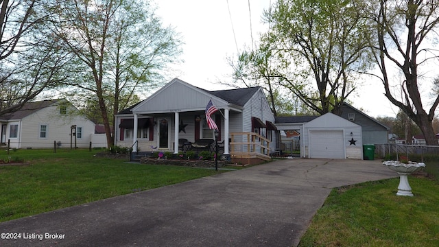 view of front of house featuring covered porch, fence, a garage, an outdoor structure, and a front yard